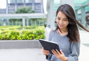 Mujer empresaria revisando datos en Tablet con jardín de fondo.